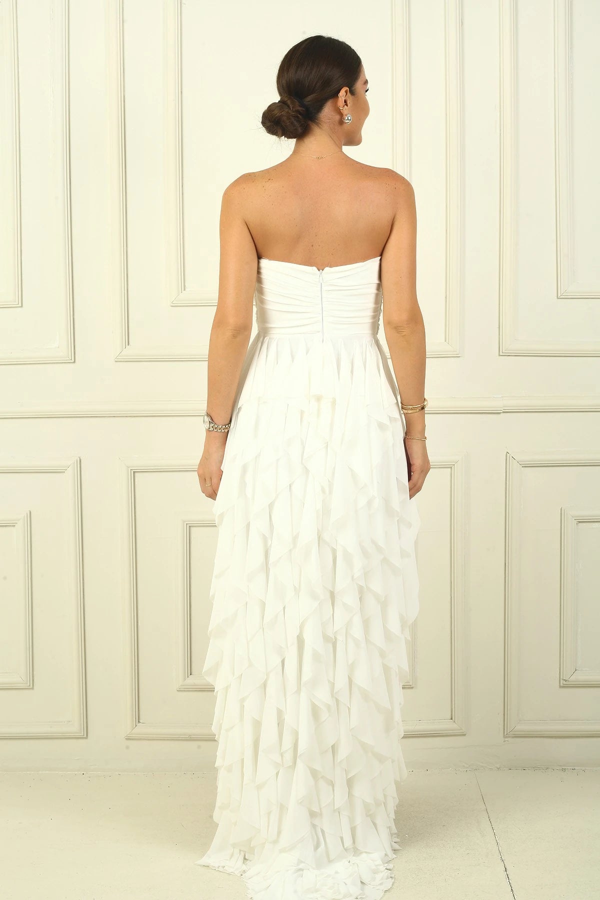 Image of Strapless, long tulle dress with stone detailing at the front, draped, lined, and with side slits and ruffles.