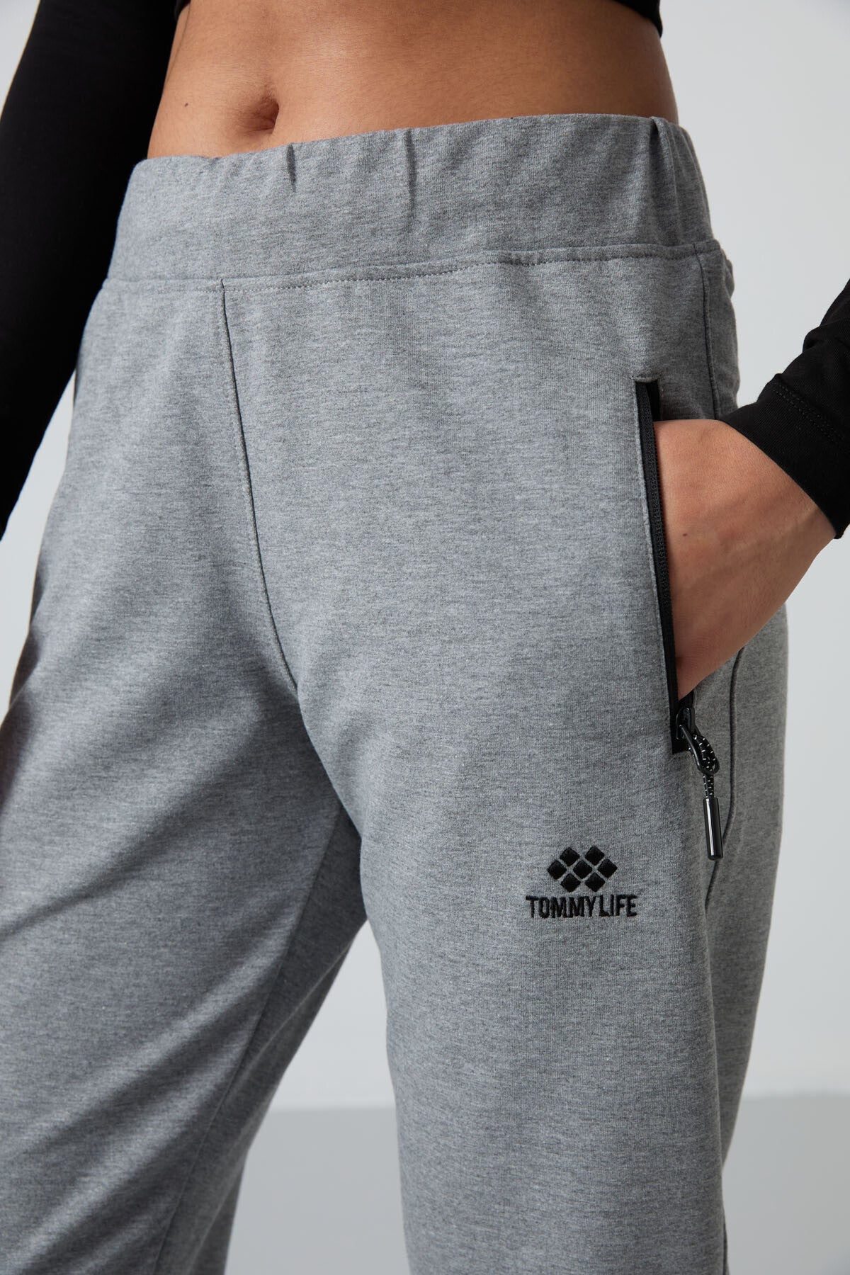 Image of Pantaloni de trening gri melanj pentru femei cu buzunare cu fermoar, croială confortabilă, model clasic pe picior - 94195